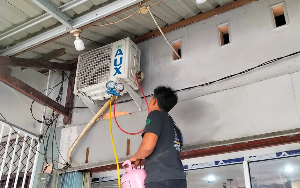 Teknisi Salman Teknik sedang melakukan pengisian freon untuk memastikan AC tetap dingin dan berfungsi secara optimal.